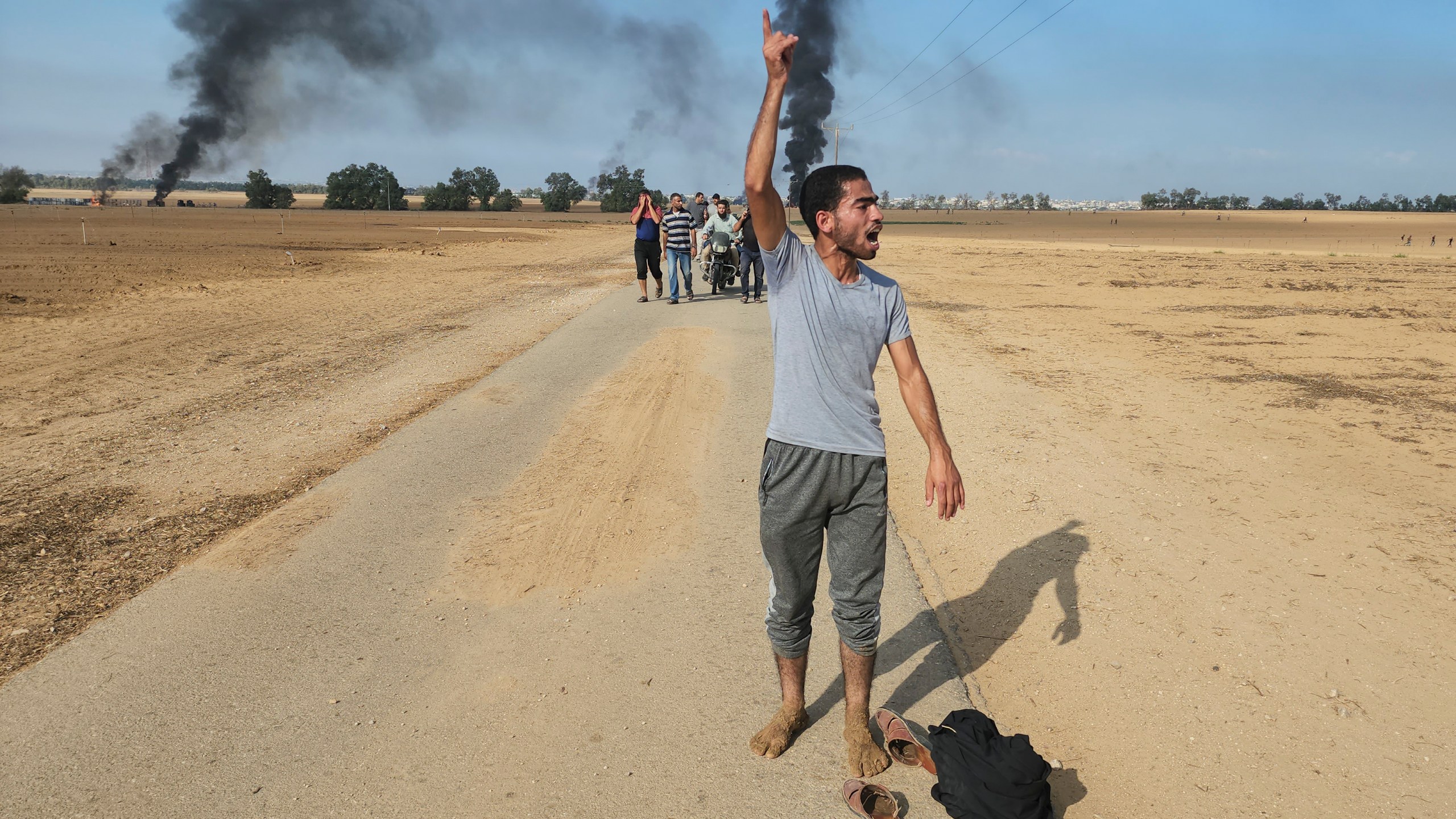 FILE - Palestinians walk away from the kibbutz of Kfar Azza, Israel, near the fence with the Gaza strip on Saturday, Oct. 7, 2023. A growing list of Israeli officials have accepted responsibility for failing to prevent Hamas’ brutal attack on Israeli communities during the Oct. 7 incursion that triggered the current Israel-Hamas war. Conspicuously absent from that roll call is Prime Minister Benjamin Netanyahu. (AP Photo, File)