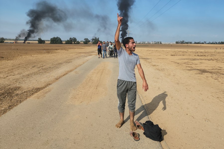 FILE - Palestinians walk away from the kibbutz of Kfar Azza, Israel, near the fence with the Gaza strip on Saturday, Oct. 7, 2023. A growing list of Israeli officials have accepted responsibility for failing to prevent Hamas’ brutal attack on Israeli communities during the Oct. 7 incursion that triggered the current Israel-Hamas war. Conspicuously absent from that roll call is Prime Minister Benjamin Netanyahu. (AP Photo, File)